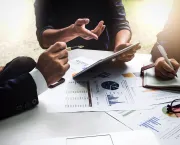 executives meeting over financials with tablets and paper