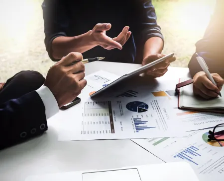 executives meeting over financials with tablets and paper