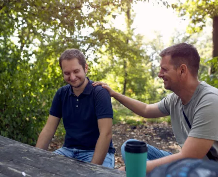 two males talking in nature setting