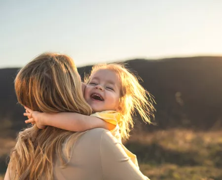 little girl hugging mom in sunshine