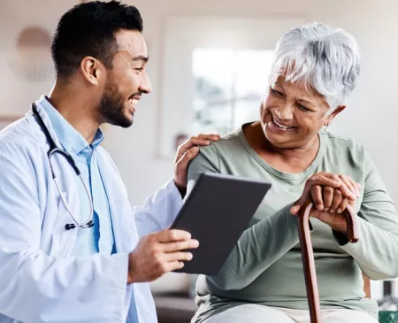 older woman with cane talking to doctor