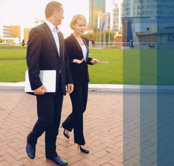 a business man and woman walking and talking outside