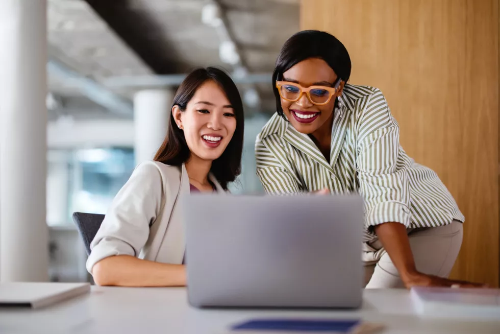 happy coworkers looking at laptop